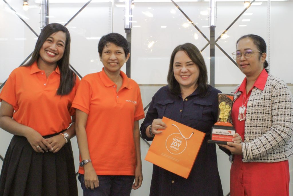 Group photo of World Vision Development Foundation, Inc. members and the Executive Vice President of 1Rotary at a collaborative community development event.