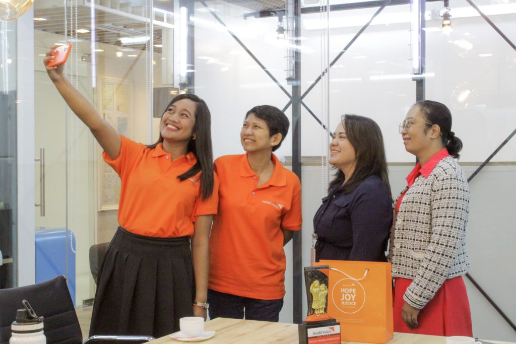 Group photo of World Vision Development Foundation, Inc. members and the Executive Vice President of 1Rotary at a collaborative community development event.